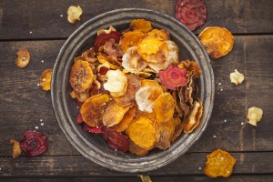 Roasted vegetable chips made of parsnips, sweet potatoes, beetroots, carrots and turnips on plate